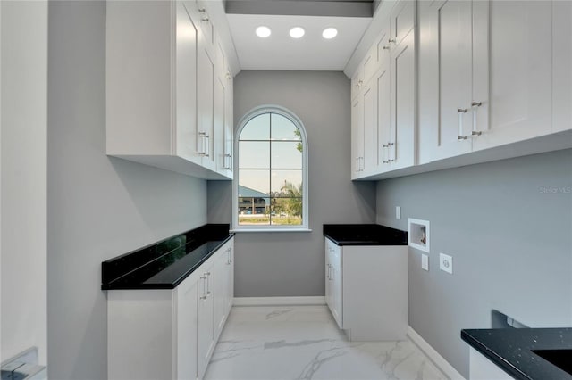 clothes washing area featuring cabinets, washer hookup, and light tile floors