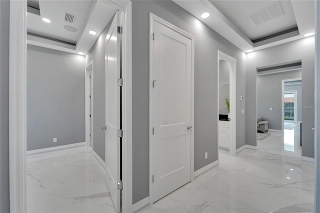 hall featuring a raised ceiling and light tile floors