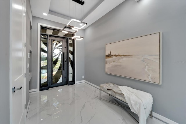 foyer featuring light tile floors and a raised ceiling