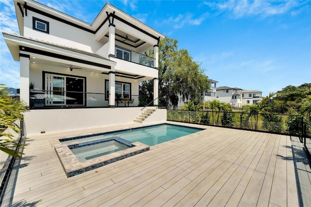 view of swimming pool with ceiling fan and an outdoor hot tub