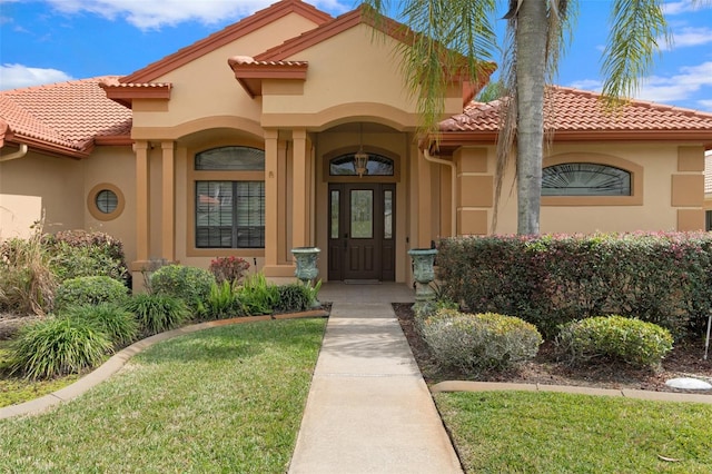 entrance to property featuring a lawn