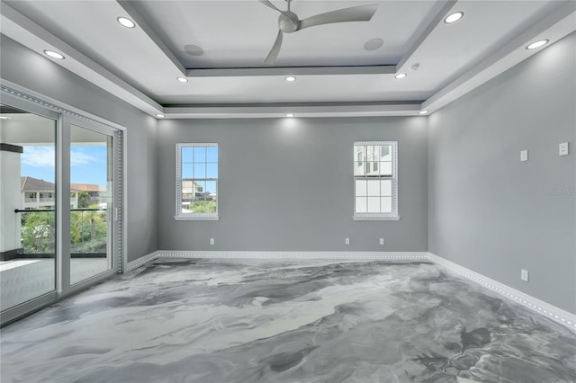 spare room featuring a tray ceiling and ceiling fan