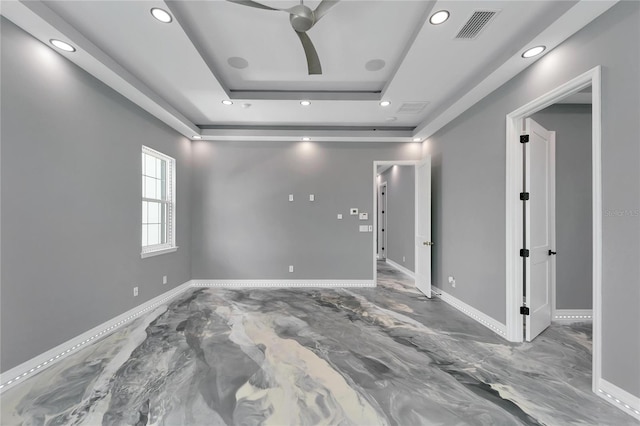 unfurnished room featuring a raised ceiling and ceiling fan