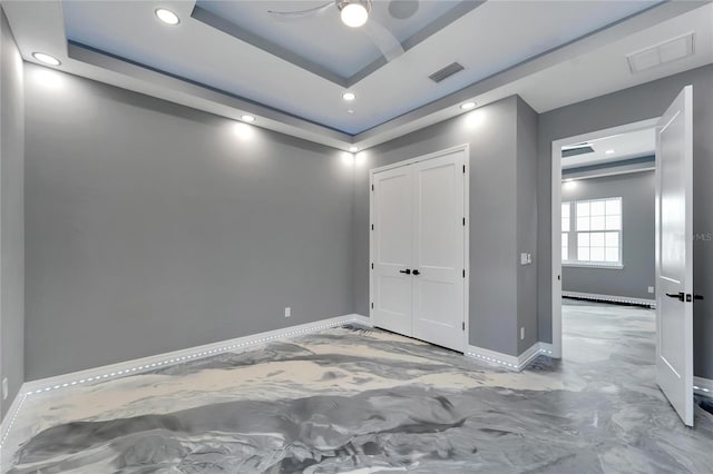 unfurnished room featuring ceiling fan and a raised ceiling