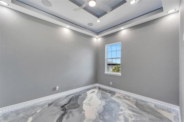 spare room featuring ceiling fan and a tray ceiling