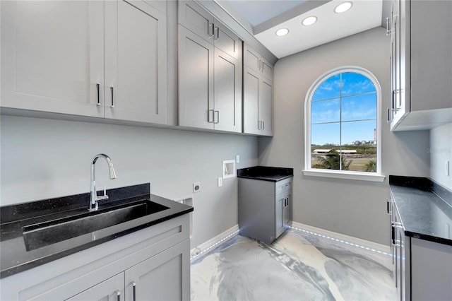 interior space featuring hookup for a washing machine, hookup for an electric dryer, cabinets, and sink