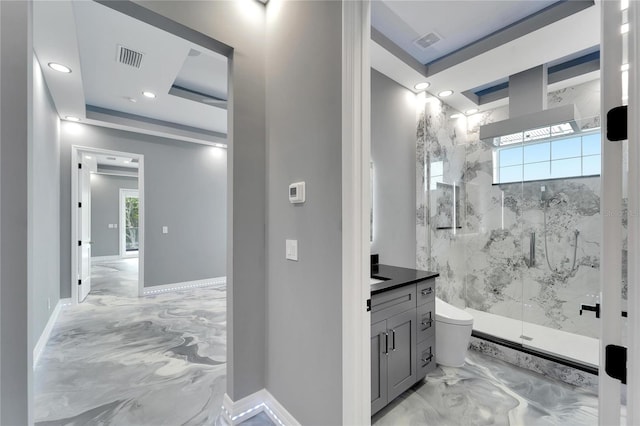 bathroom with vanity, walk in shower, a tray ceiling, tile flooring, and toilet