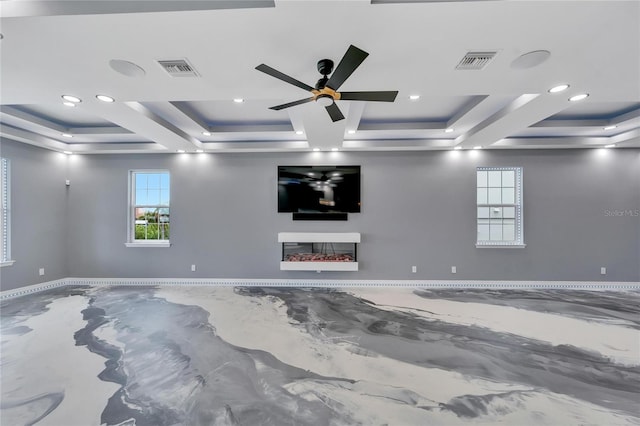 spare room featuring coffered ceiling, ceiling fan, a fireplace, and a raised ceiling