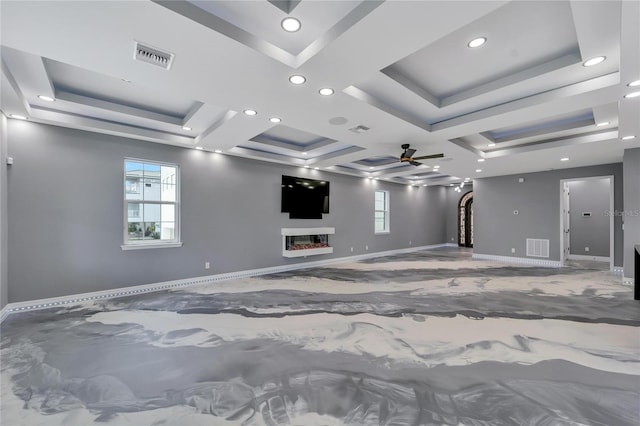 spare room with ceiling fan, a wealth of natural light, coffered ceiling, and a tray ceiling