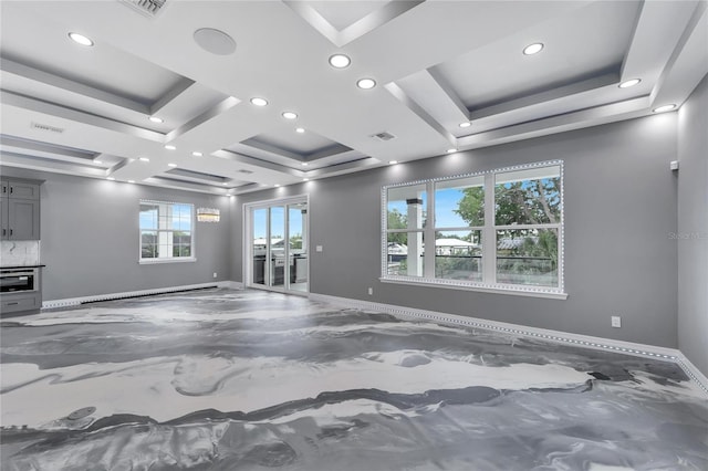 empty room featuring coffered ceiling and a raised ceiling