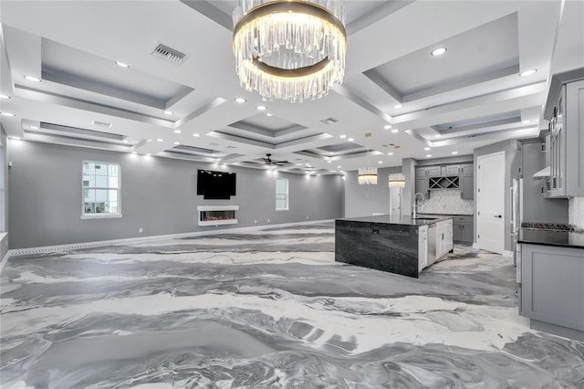 kitchen featuring coffered ceiling, pendant lighting, ceiling fan with notable chandelier, tasteful backsplash, and gray cabinets