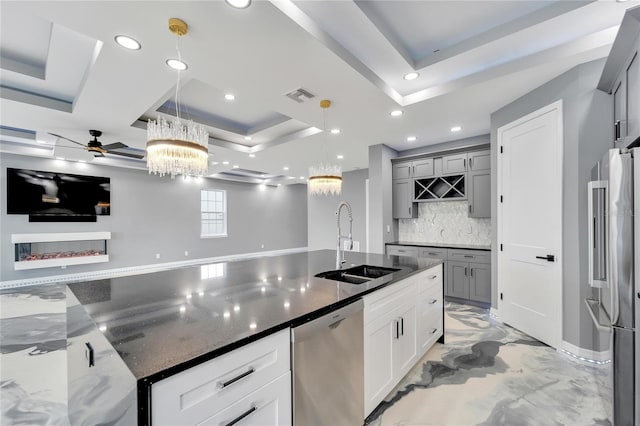 kitchen with decorative light fixtures, gray cabinetry, and sink