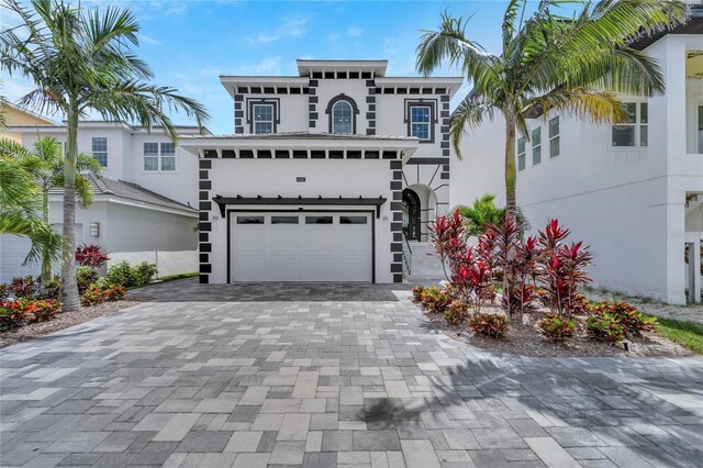 view of front of home with a garage, decorative driveway, and stucco siding