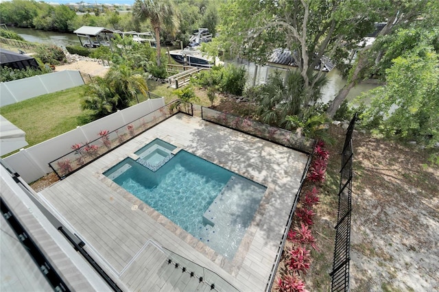 view of pool with a pool with connected hot tub, a fenced backyard, and a patio