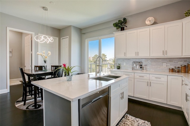 kitchen with an island with sink, pendant lighting, sink, white cabinets, and stainless steel dishwasher