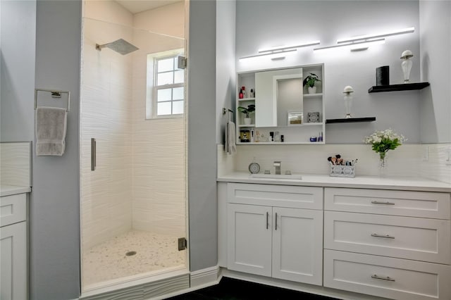 bathroom featuring backsplash, an enclosed shower, and vanity