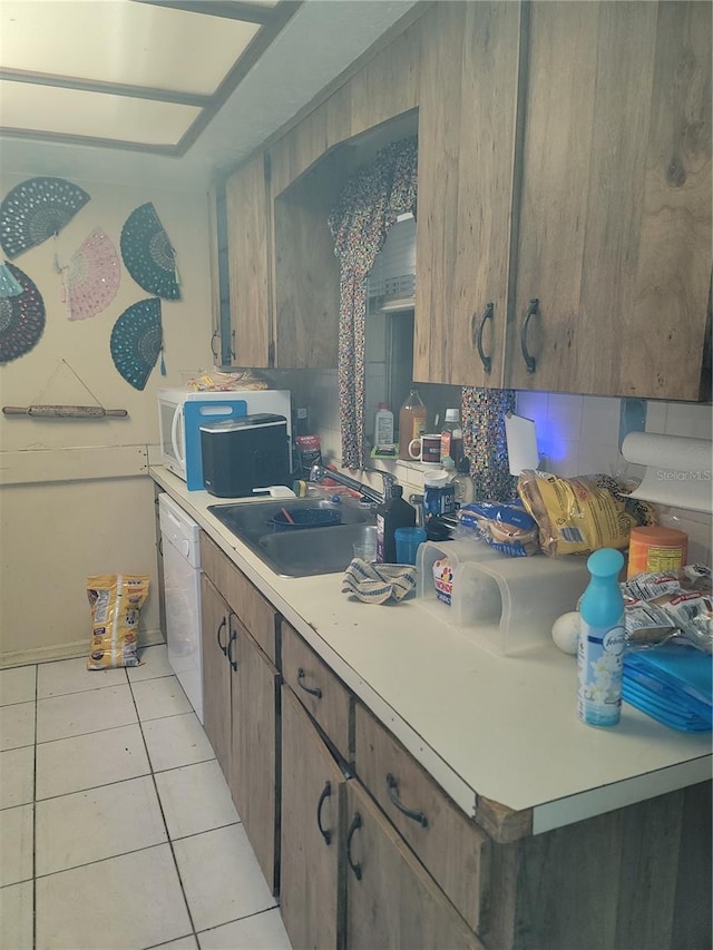 kitchen with backsplash, white dishwasher, light tile floors, and sink