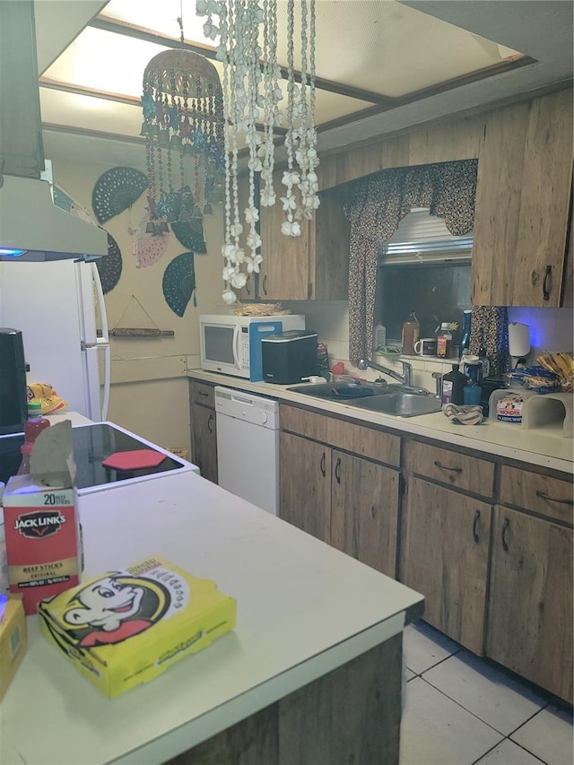 kitchen featuring white appliances, sink, light tile floors, fume extractor, and decorative light fixtures