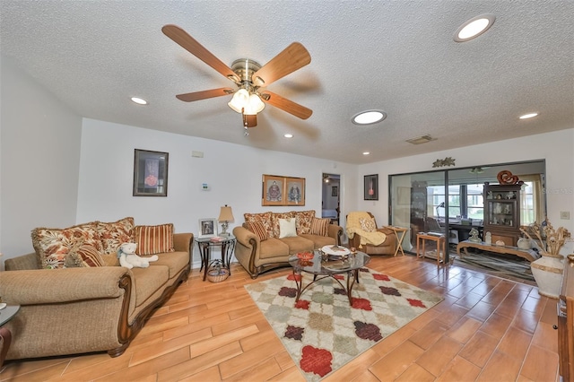 living room with ceiling fan, hardwood / wood-style floors, and a textured ceiling