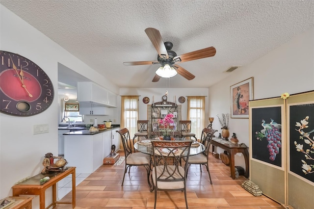 dining room with a textured ceiling, ceiling fan, a healthy amount of sunlight, and sink