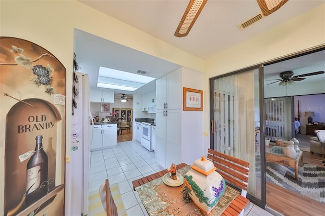 interior space with white appliances, light hardwood / wood-style floors, and white cabinetry