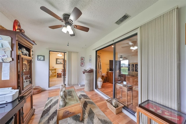 interior space with a textured ceiling and light hardwood / wood-style flooring