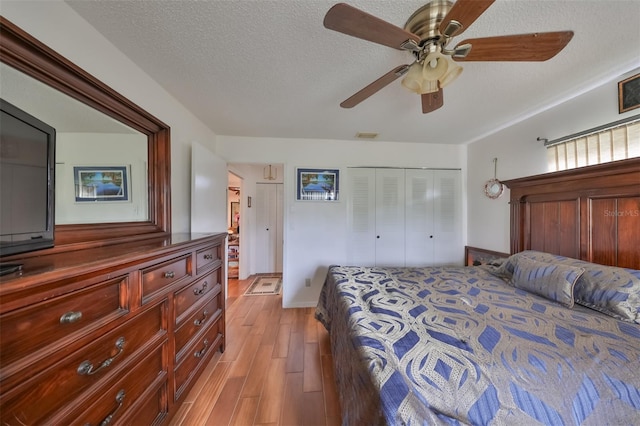 bedroom featuring a textured ceiling, a closet, light hardwood / wood-style floors, and ceiling fan