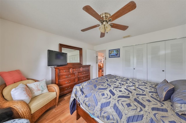 bedroom featuring ceiling fan, a closet, and light hardwood / wood-style floors