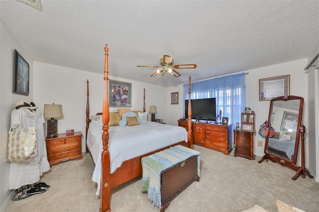 carpeted bedroom featuring ceiling fan and a textured ceiling