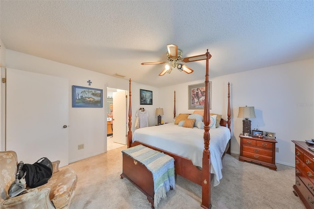 carpeted bedroom with a textured ceiling, ceiling fan, and ensuite bathroom