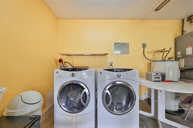 washroom featuring a textured ceiling, separate washer and dryer, and water heater