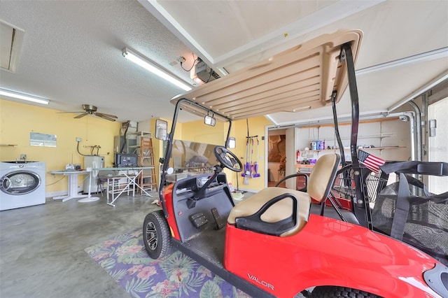 garage with electric water heater, ceiling fan, and washer / dryer