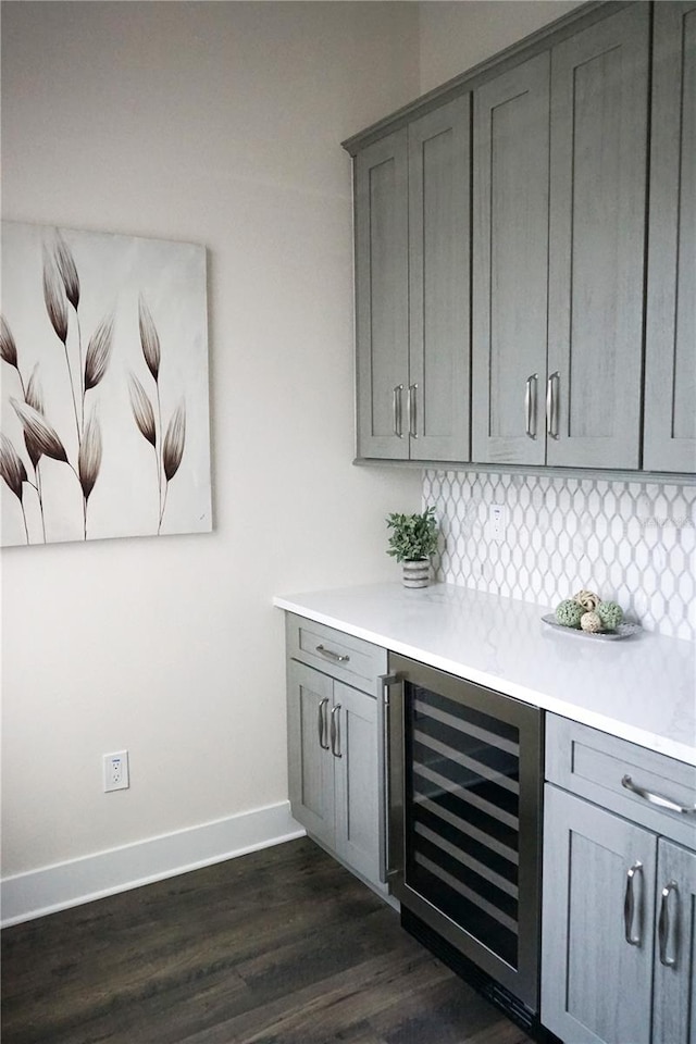 bar featuring gray cabinets, beverage cooler, and tasteful backsplash