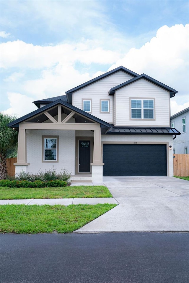 view of front of house with metal roof, an attached garage, fence, concrete driveway, and a standing seam roof