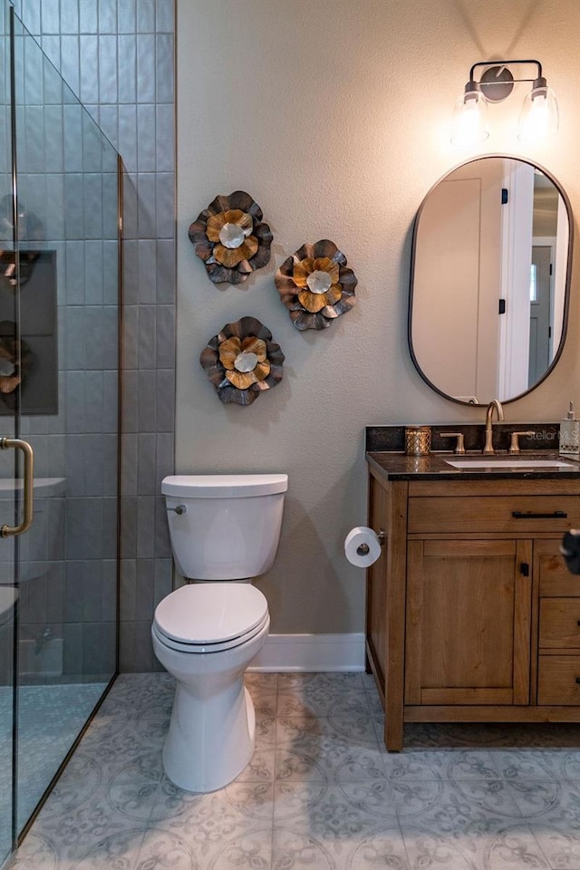 bathroom featuring vanity, tile patterned flooring, a shower with door, and toilet