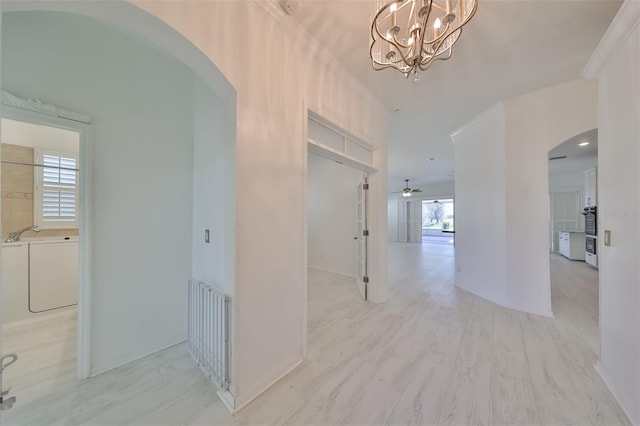 hall featuring a notable chandelier and light wood-type flooring