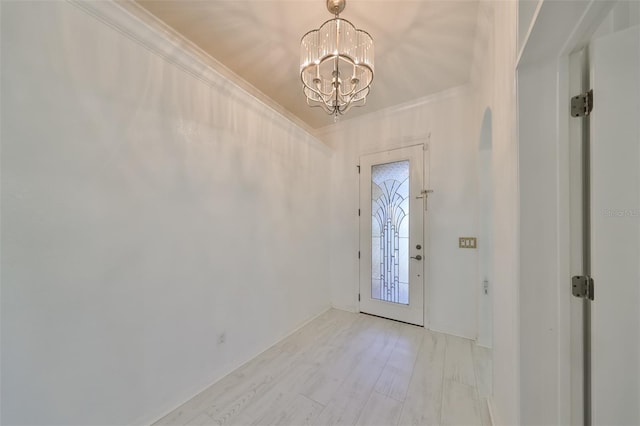 foyer featuring light hardwood / wood-style floors, a chandelier, and crown molding