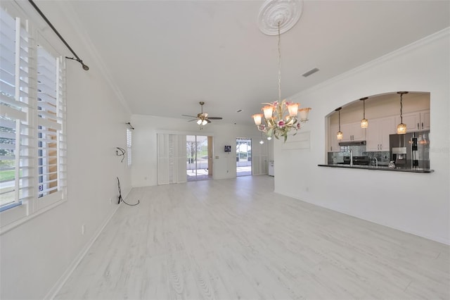 interior space with ornamental molding, wood-type flooring, and ceiling fan with notable chandelier