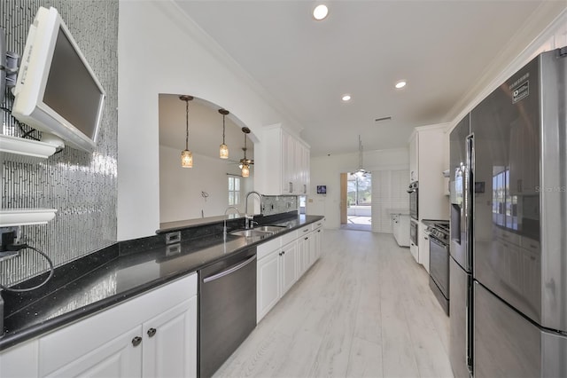 kitchen with white cabinets, sink, appliances with stainless steel finishes, and pendant lighting