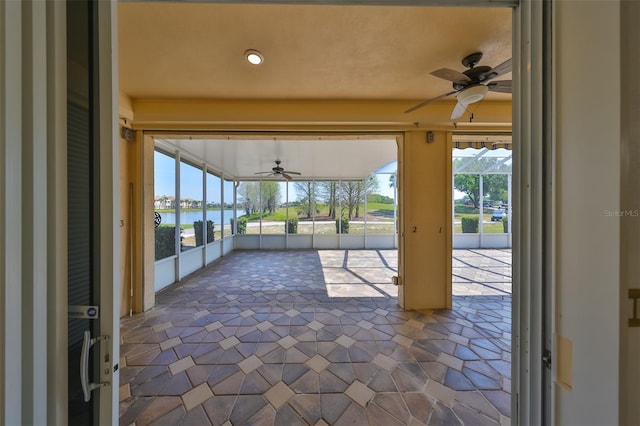 view of patio featuring a water view and ceiling fan