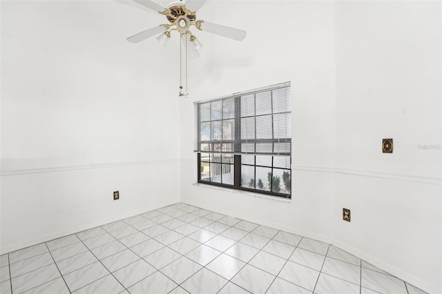 empty room with ceiling fan and light tile patterned flooring