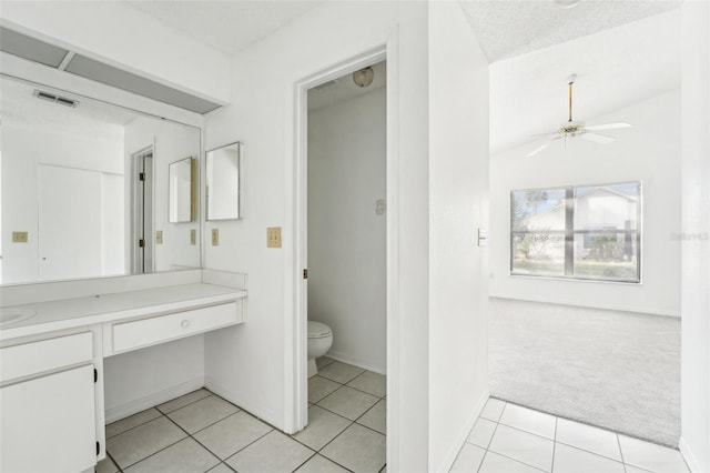 bathroom with vanity, tile patterned floors, ceiling fan, toilet, and a textured ceiling