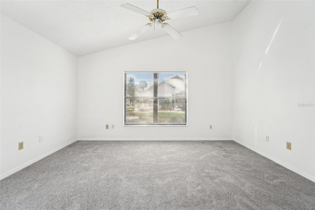 carpeted spare room with ceiling fan and vaulted ceiling