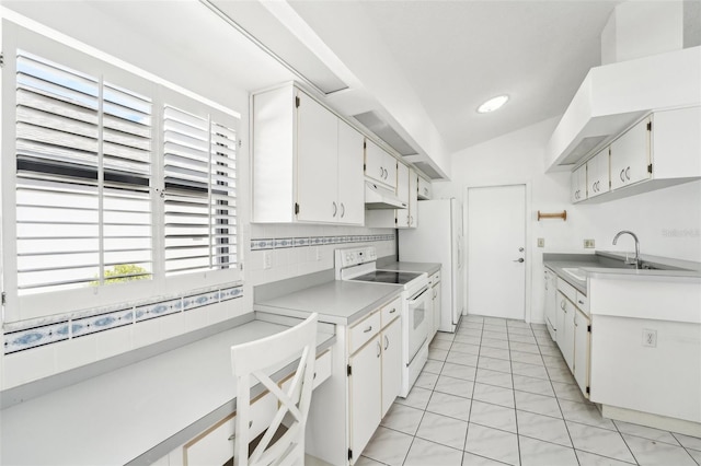 kitchen featuring white appliances, sink, white cabinets, lofted ceiling, and light tile patterned flooring