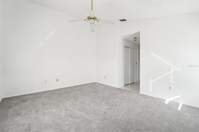 carpeted spare room with ceiling fan and a textured ceiling