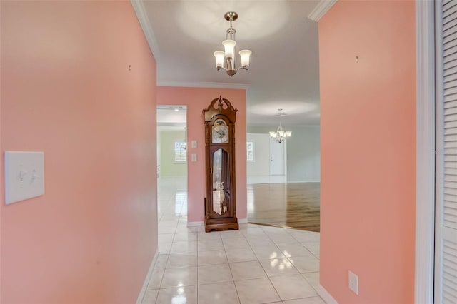 corridor featuring light tile flooring, ornamental molding, and a notable chandelier