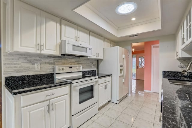 kitchen with white appliances, white cabinets, a tray ceiling, and sink