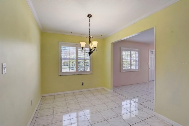 tiled spare room featuring crown molding, a healthy amount of sunlight, and a chandelier