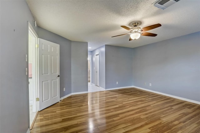 empty room featuring light hardwood / wood-style floors, a textured ceiling, and ceiling fan