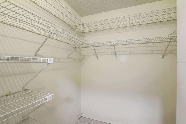 spacious closet featuring light tile floors